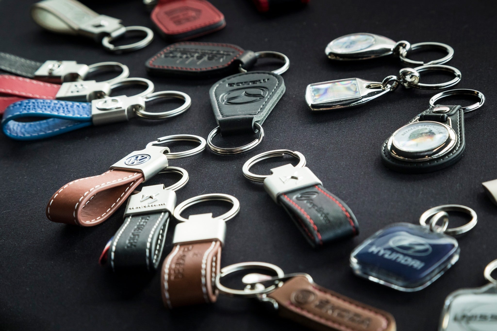Collectie sleutelhangers in metaal en kunstleder met logo